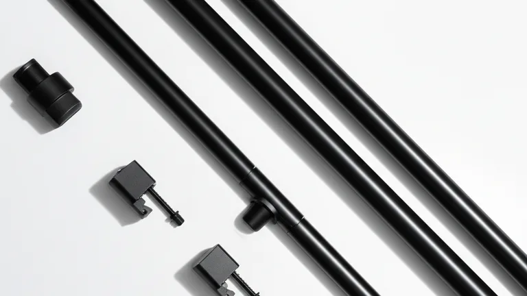 Flat lay overhead product photography of telescopic steel window security bar components in matte black finish on white surface