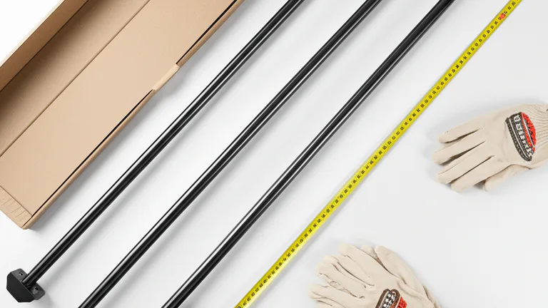 Flat lay product photograph of telescopic steel window security bars with measuring tape, level, and work gloves on white surface