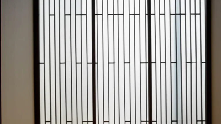 Modern apartment bedroom with matte black steel window security bars casting geometric shadow patterns on hardwood floor