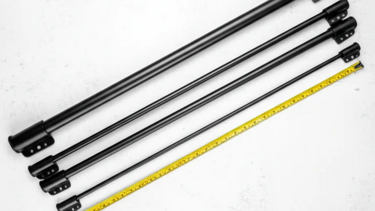 Overhead flat lay of three matte black telescopic steel window security bars at different extension lengths on a white surface